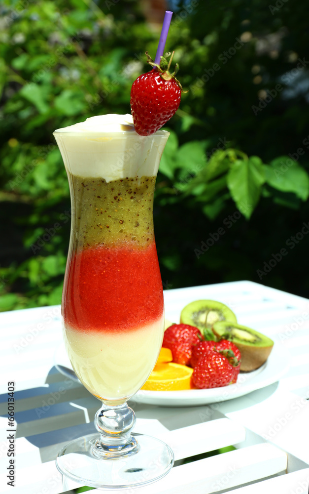 Delicious fruit smoothie on white table, outdoors Delicious fruit smoothie on white table, outdoors