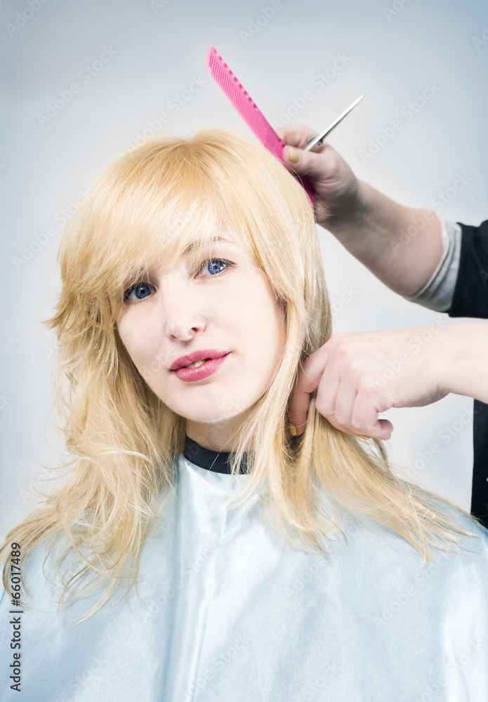 Hairdresser cuts (trims) blond long hair Hairdresser cuts (trims) blond long hair