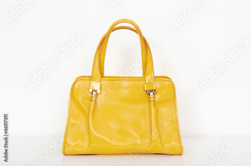  Cute yellow summer purse on white shelf.