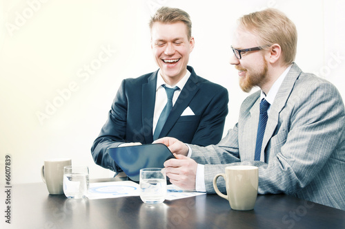 Men Laughing Together at Tablet's Screen