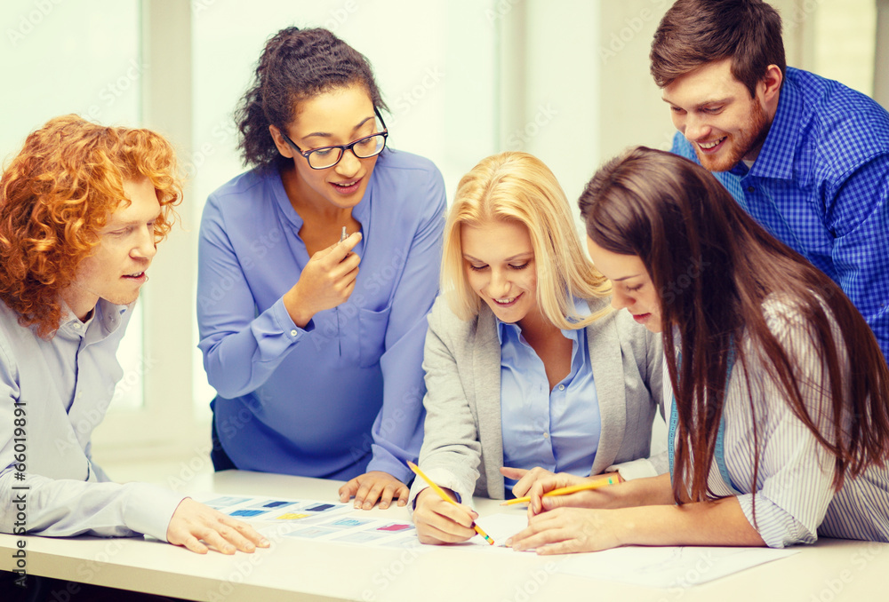 smiling creative team looking over clothes designs smiling creative team looking over clothes designs