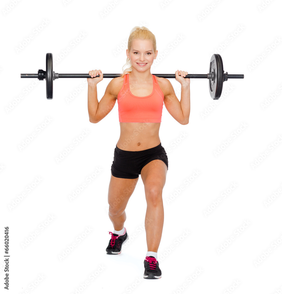 Obraz premium smiling sporty woman exercising with barbell