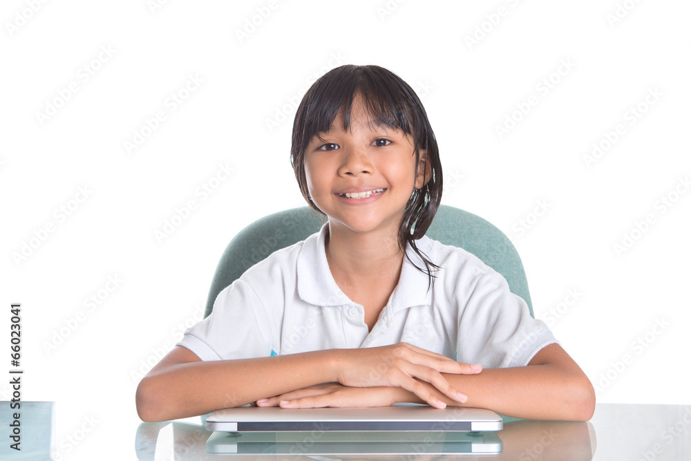 Young Asian Malay girl sitting at her desk with a laptop Young Asian Malay girl sitting at her desk with a laptop