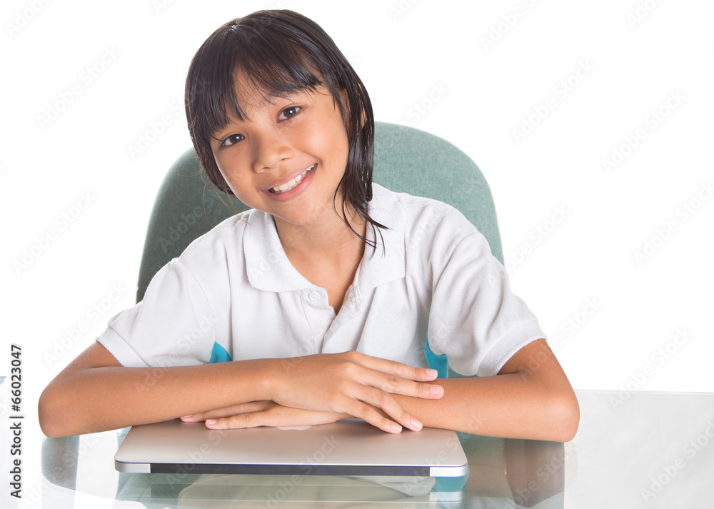 Young Asian Malay girl sitting at her desk with a laptop Young Asian Malay girl sitting at her desk with a laptop