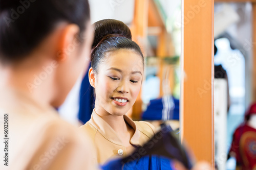 Frau beim Kleidung anprobieren im Spiegel
