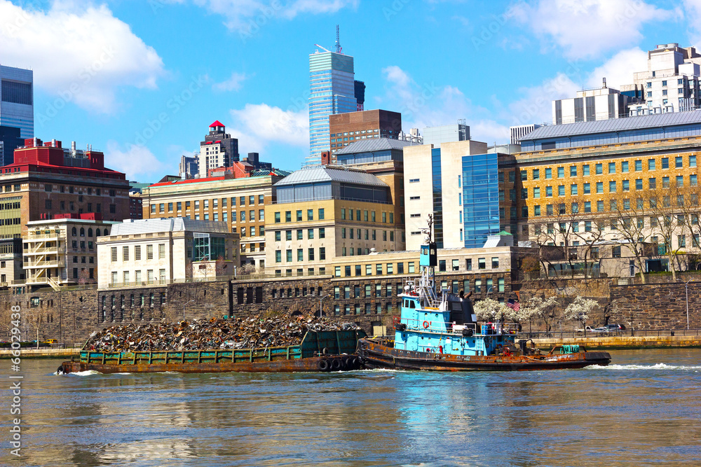 Daily trash removal by large barges in New York.