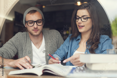 Hipster young couple studying together at cafe