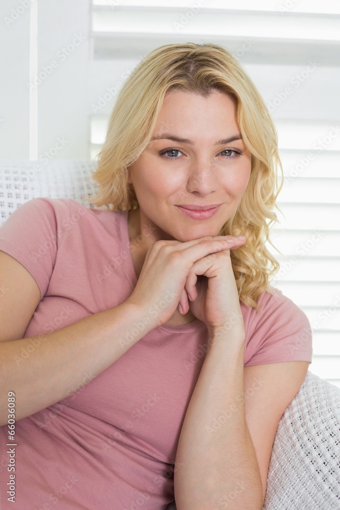 Happy blonde relaxing on the couch smiling at camera Happy blonde relaxing on the couch smiling at camera
