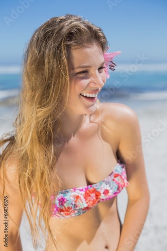Beautiful happy blonde with flower hair accessory on the beach