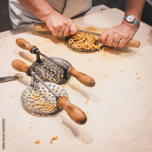 Preparation of passatelli fresh pasta using traditional tool photo