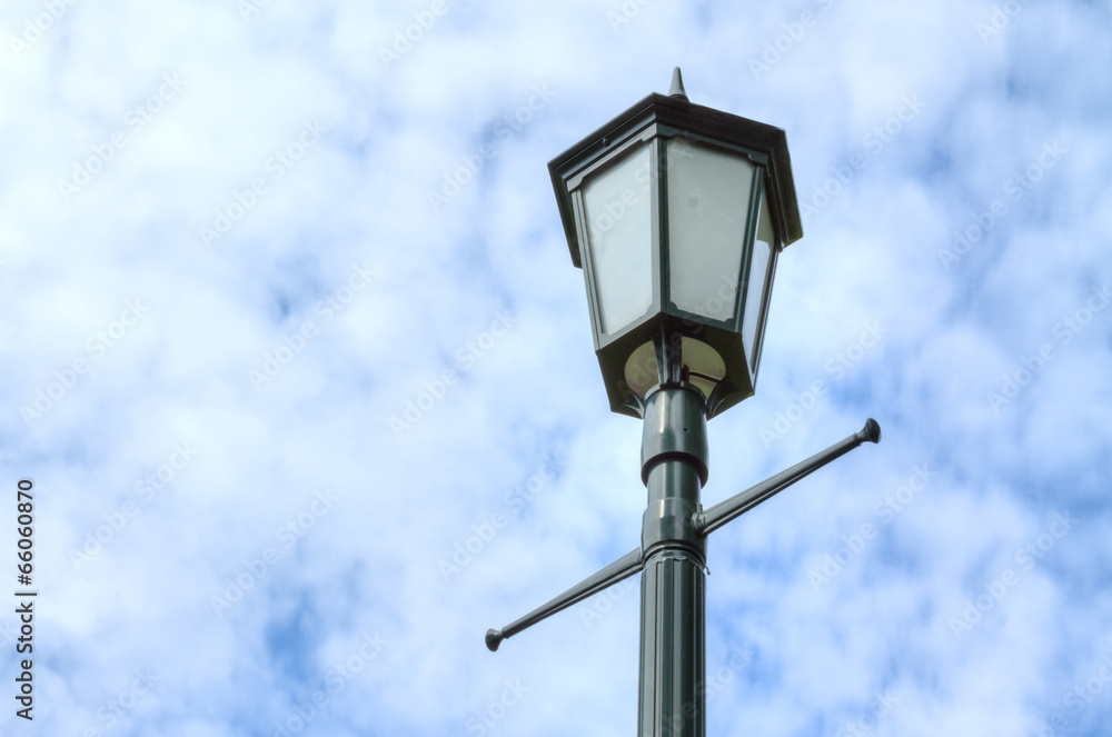 Lamp post against cloudy sky