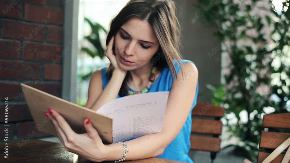Young woman reading menu in cafe Young woman reading menu in cafe