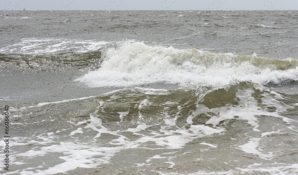 Waves with white crests inundate the sandy beach
