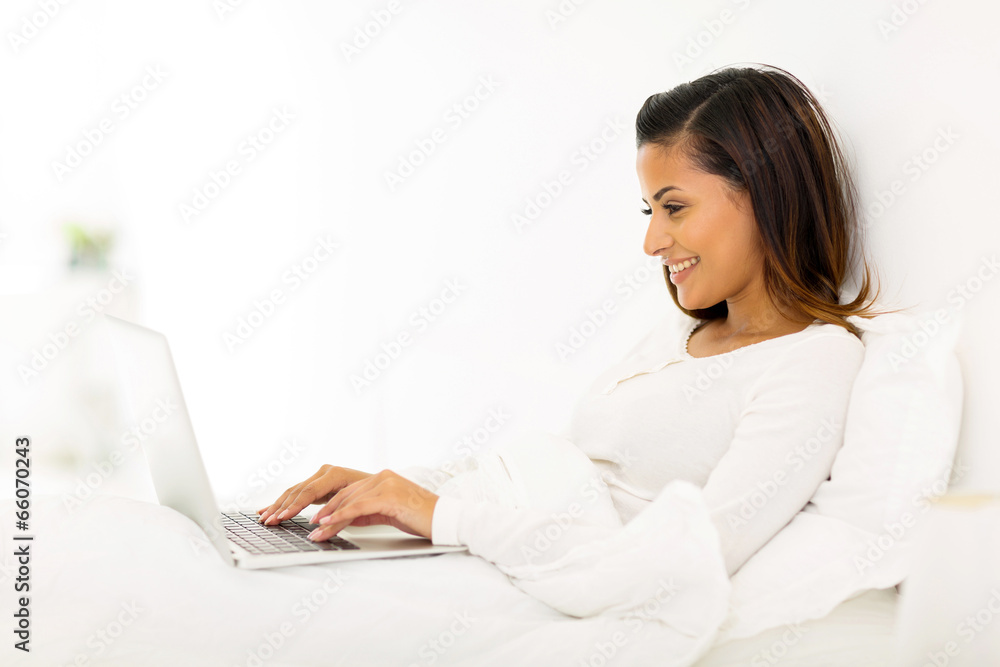 young woman using laptop on bed young woman using laptop on bed
