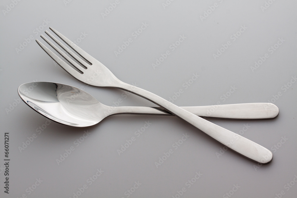 a silver fork with spoon isolated on gray background a silver fork with spoon isolated on gray background