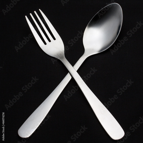 a silver fork with spoon isolated on black background