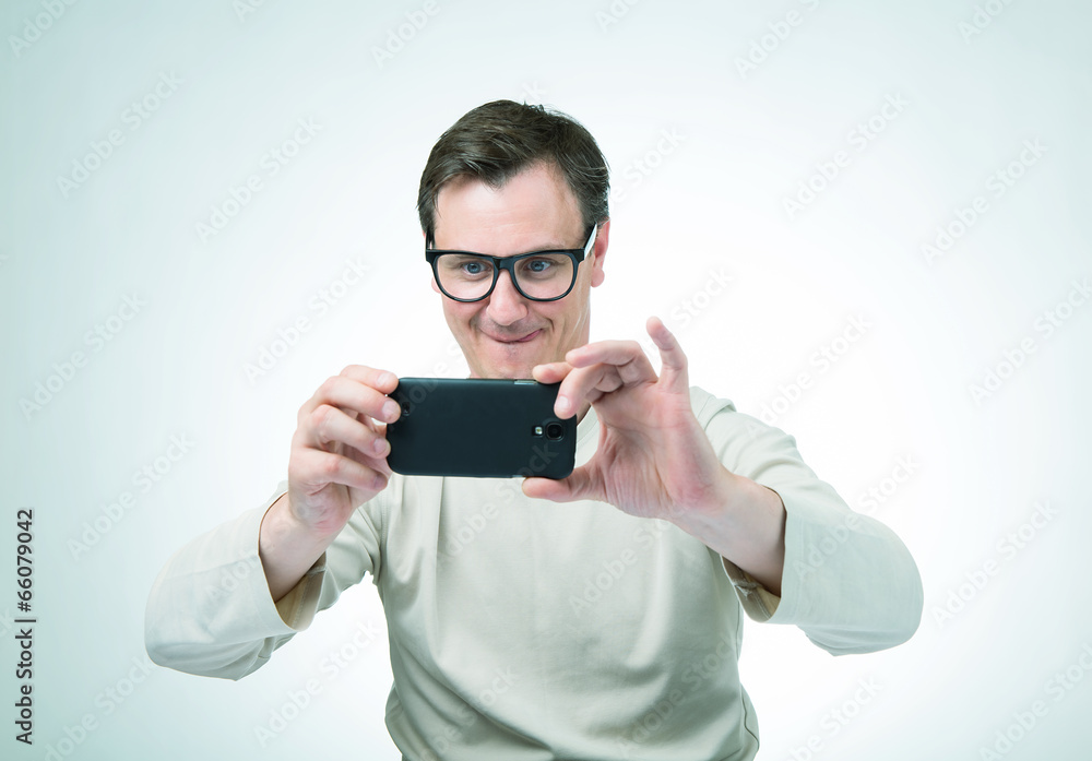 Man in glasses photographed by smartphone