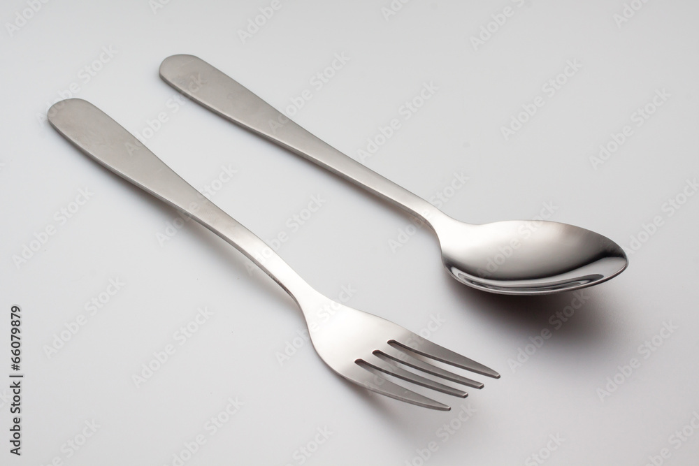 a silver fork with spoon isolated on gray background a silver fork with spoon isolated on gray background