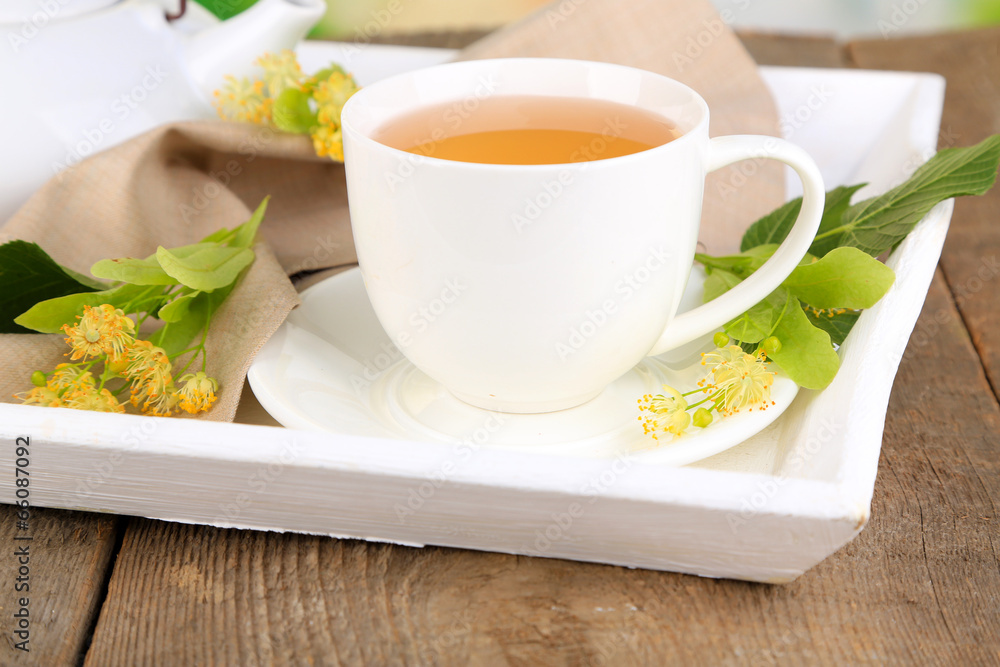 Tasty herbal tea with linden flowers on wooden table Tasty herbal tea with linden flowers on wooden table