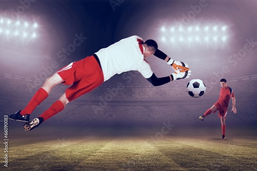 Composite image of fit goal keeper jumping up