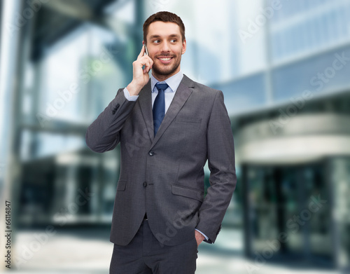 young smiling businessman with smartphone