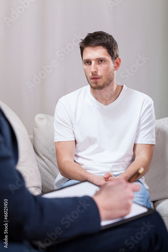 Sad man talking with psychotherapist