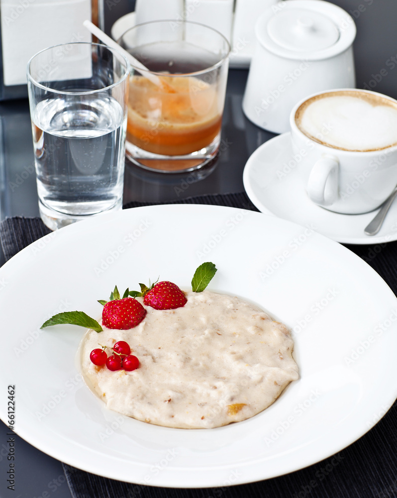 Semolina porridge in a plate with fresh strawberries. Health Bre Semolina porridge in a plate with fresh strawberries. Health Bre