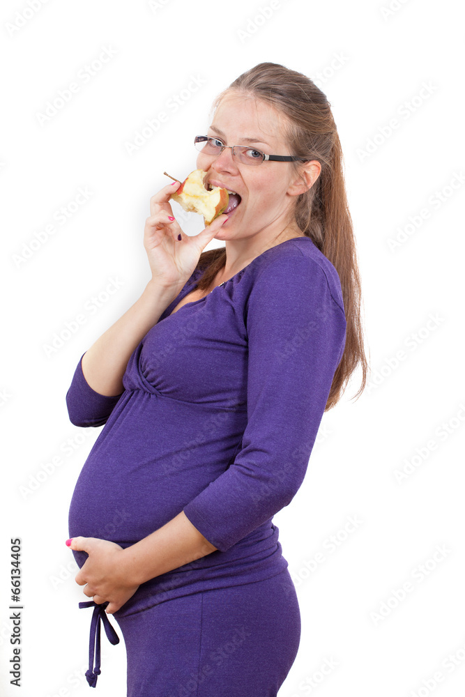 Pregnant woman eats an apple in a purple suit and glasses Pregnant woman eats an apple in a purple suit and glasses