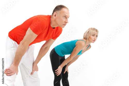 man and woman stretching on white background.