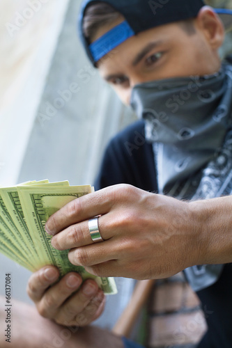close up of criminal man holding money.