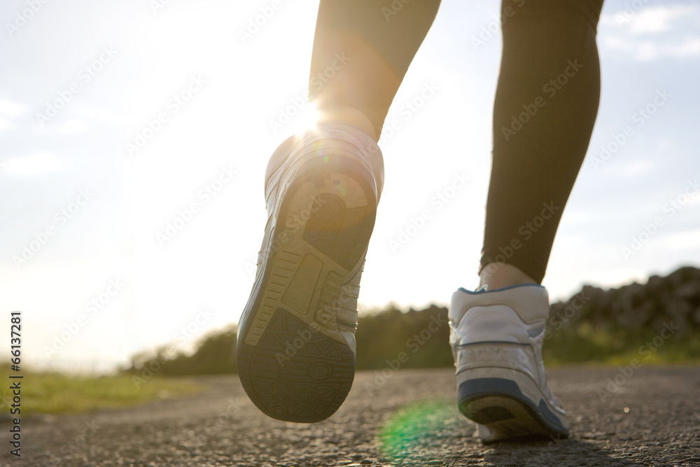 Low angle of woman jogging on street Low angle of woman jogging on street