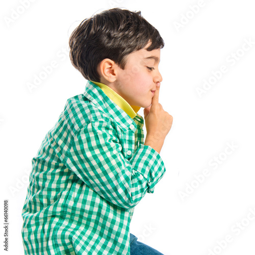 Kid doing silence gesture over white background