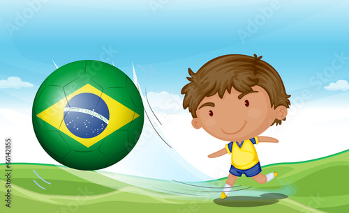 A boy beside the flag of Brazil