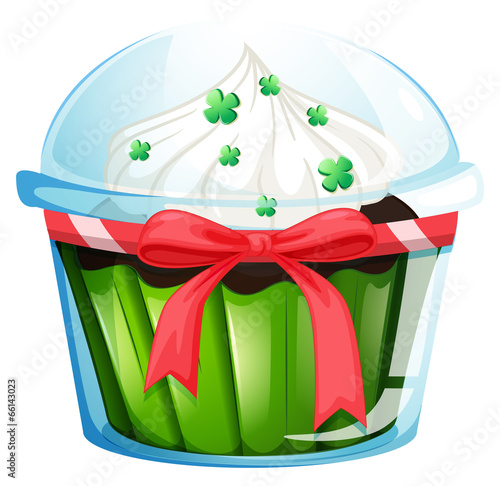 A cupcake container with a green cupcake and a pink ribbon