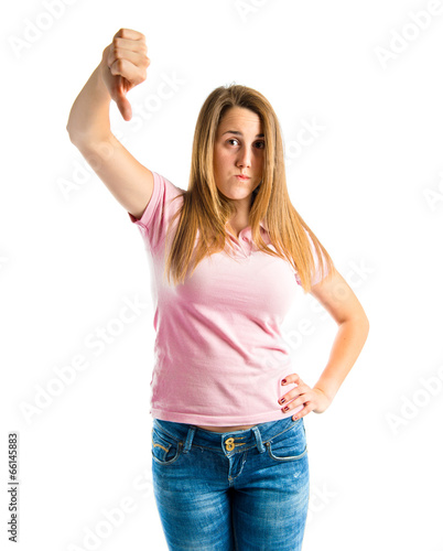 Young girl doing a bad signal over white background