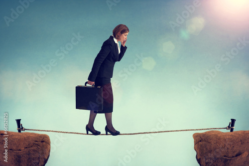 confident businesswoman walking a tightrope