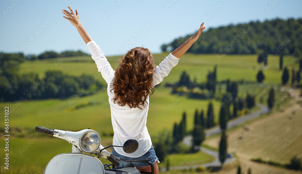Fototapeta premium Young beautiful italian woman sitting on a italian scooter in tu