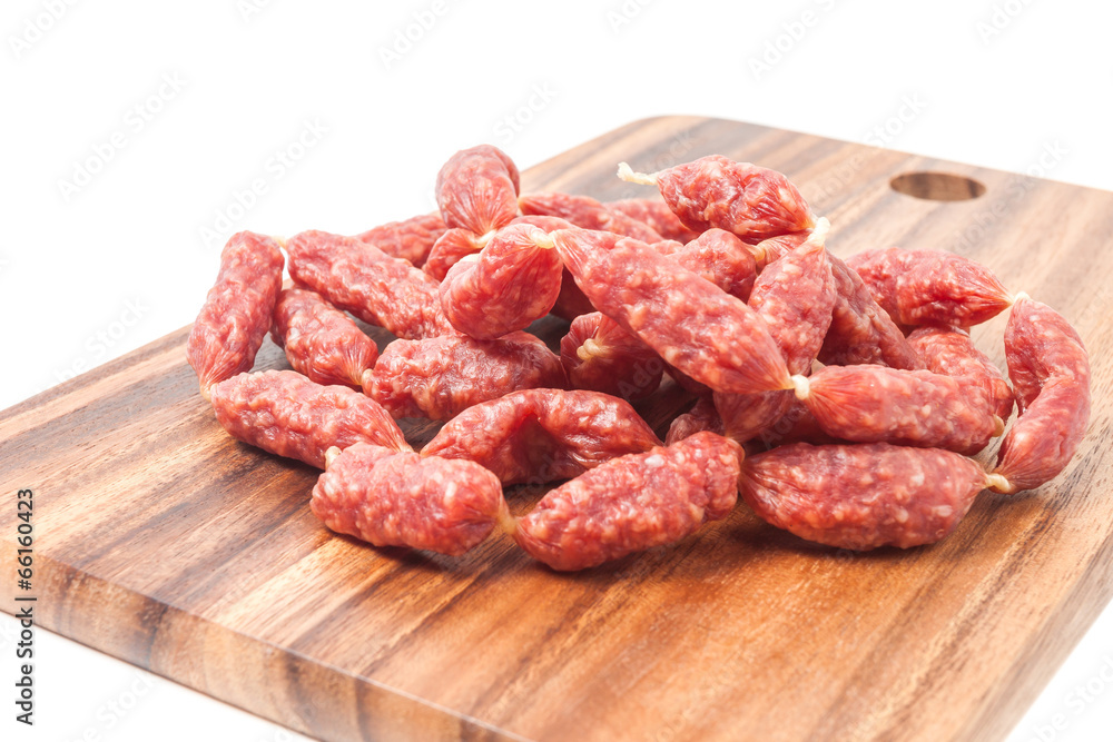A heap of mini Salamis on wooden board A heap of mini Salamis on wooden board
