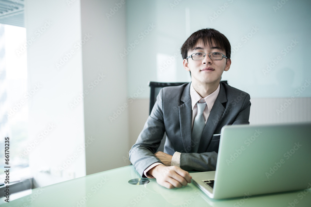 Young handsome man using laptop in his office Young handsome man using laptop in his office
