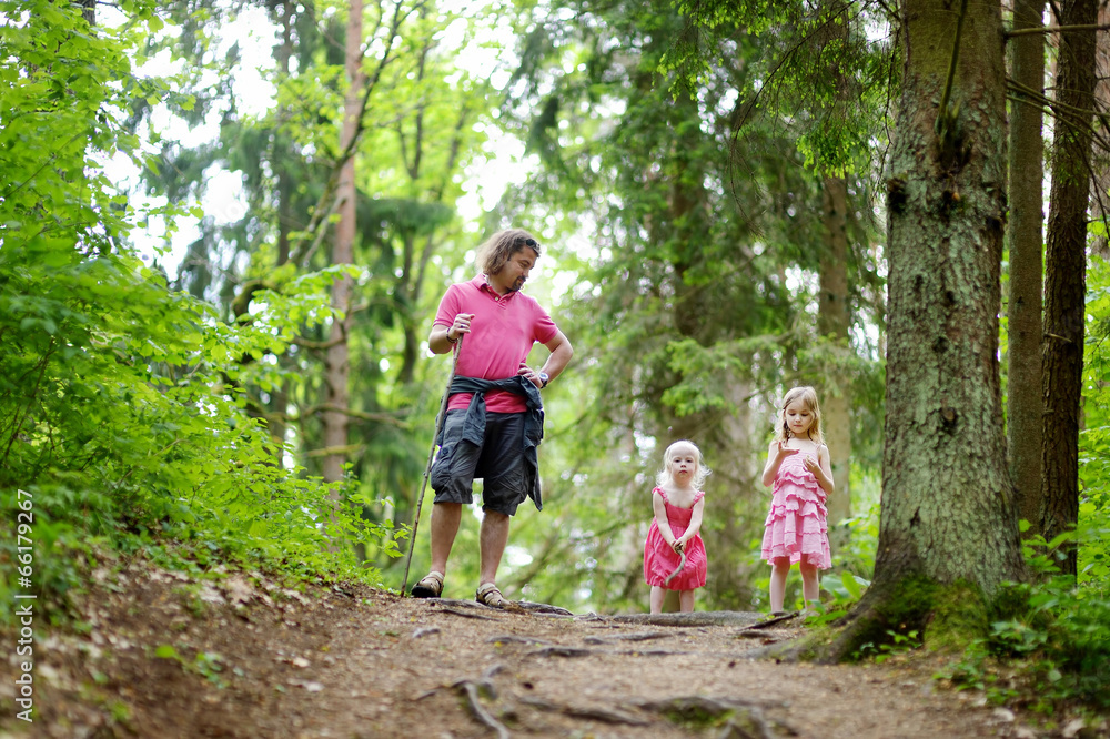Two cute little sisters and their father outdoors Two cute little sisters and their father outdoors