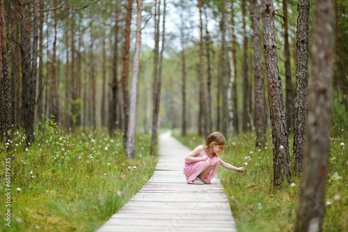 Fotografi Cute little girl walking in the woods