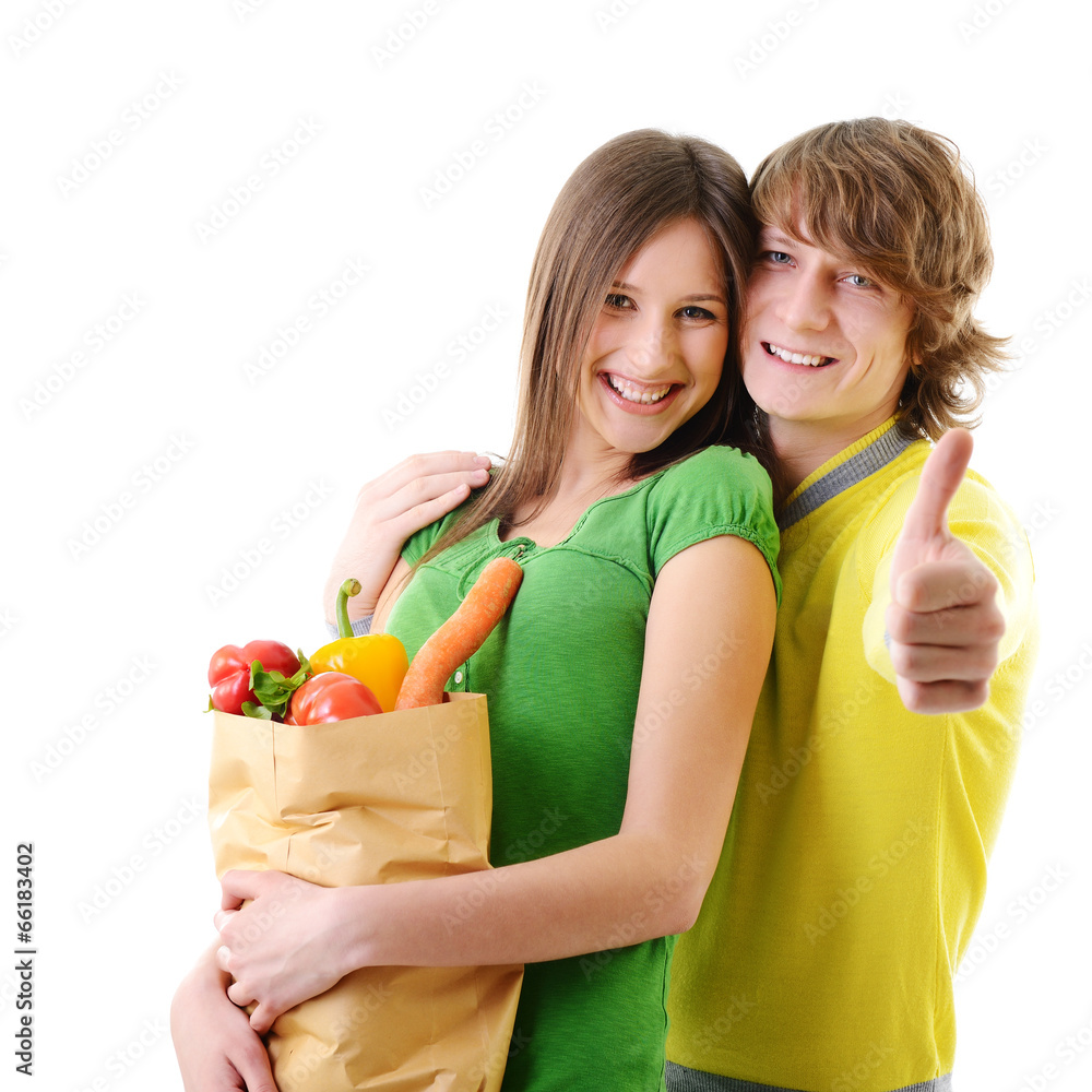 Portrait of a pretty young couple holding a grocery bag and smil Portrait of a pretty young couple holding a grocery bag and smil