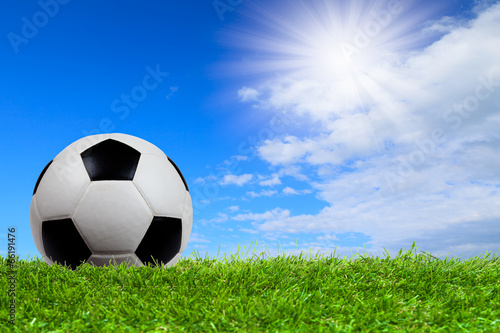 Soccer ball on grass with blue sky © PinkBlue