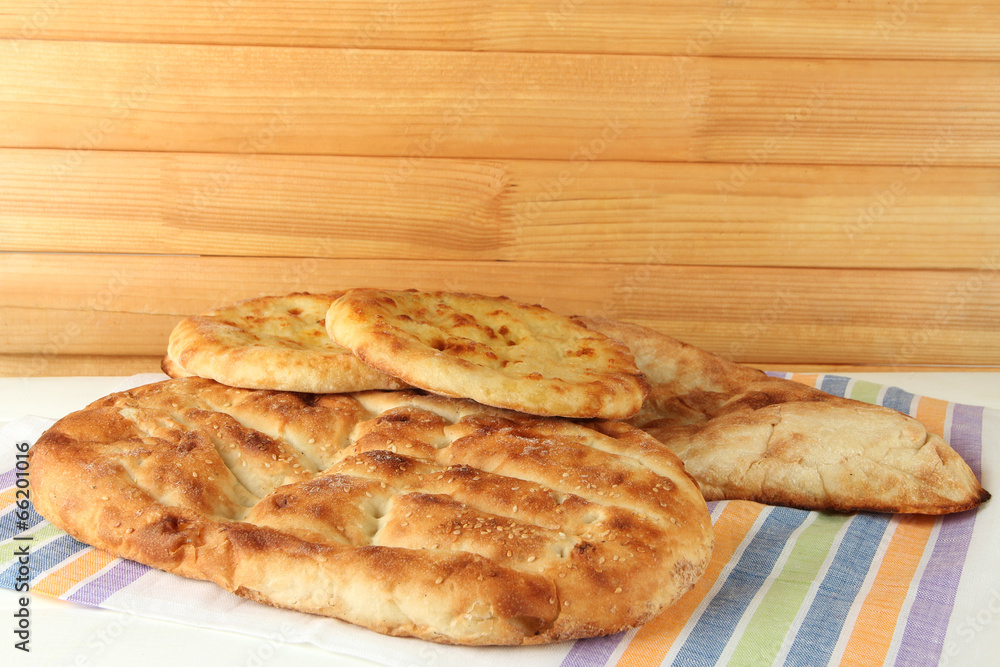 Pita breads on tablecloth on wooden background Pita breads on tablecloth on wooden background