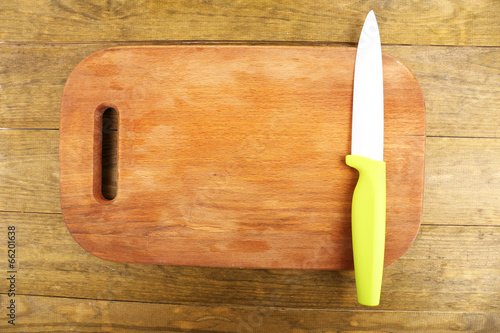 Kitchen knife and cutting board on wooden table