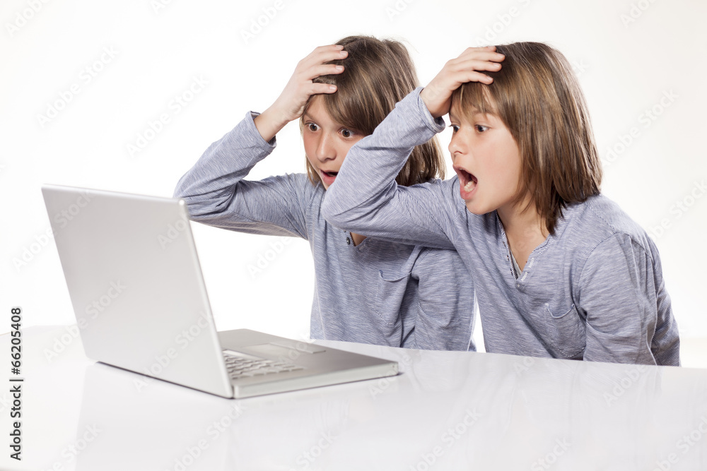 stunned two twin brothers looking at laptop stunned two twin brothers looking at laptop