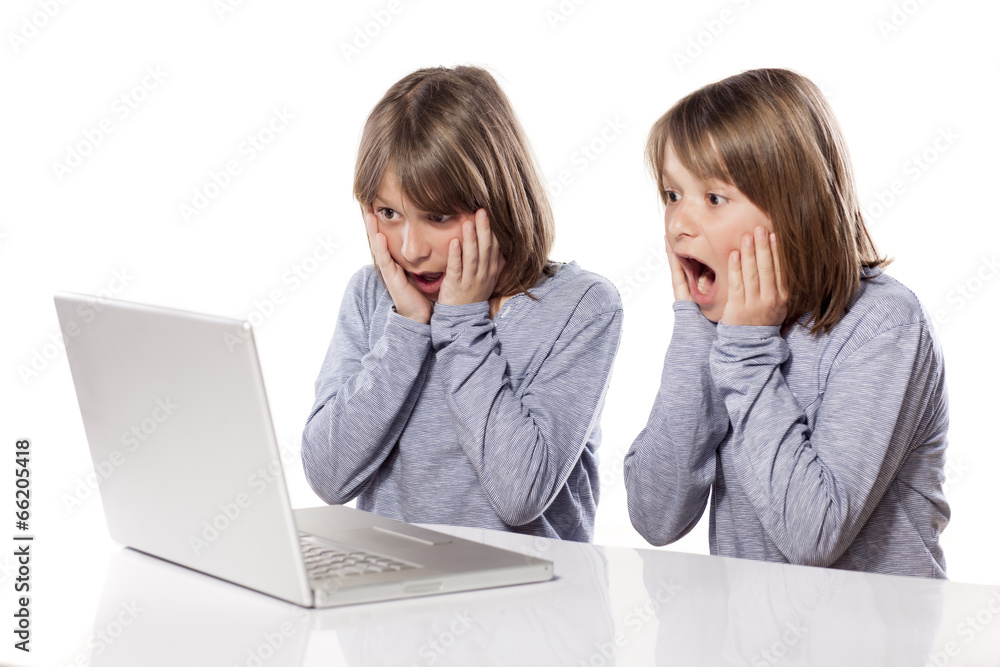 stunned two twin brothers looking at laptop stunned two twin brothers looking at laptop