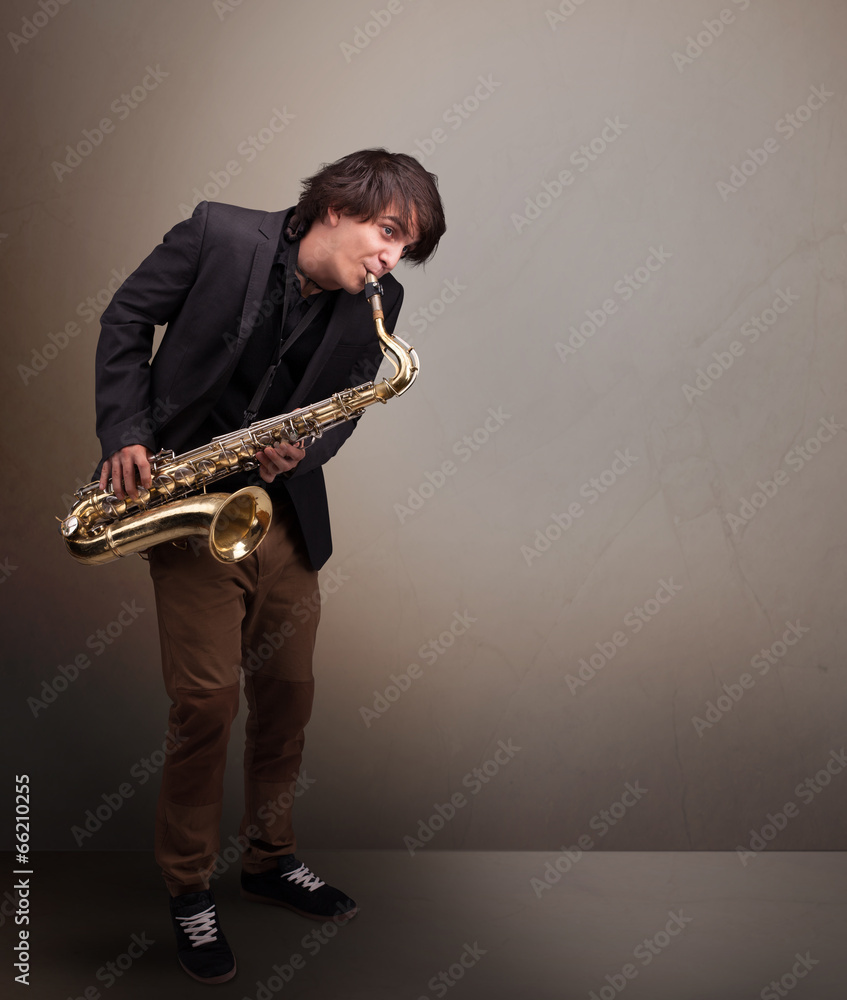 Naklejka premium Young musician playing on saxophone