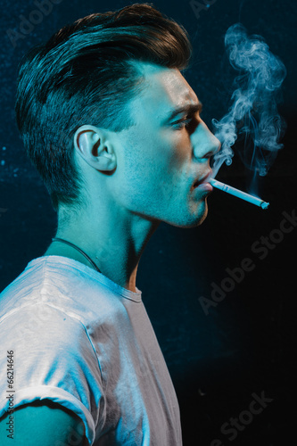 Handsome young man smoking cigarette