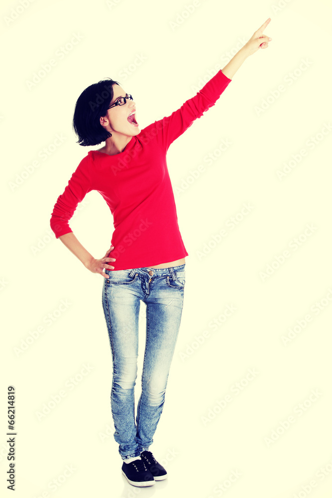 Excited young woman pointing on copy space Excited young woman pointing on copy space